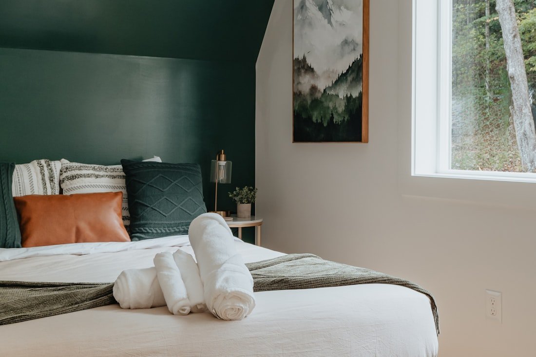 Well-staged Airbnb bedroom with folded towels, an example of a strong listing photo