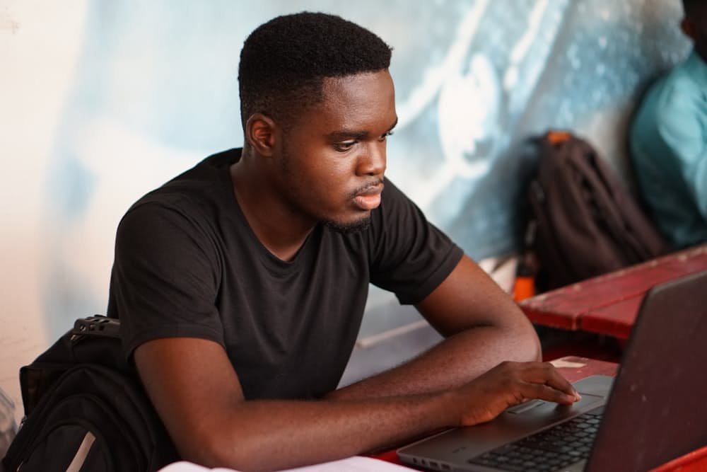 Student studying on a laptop at an outdoor table